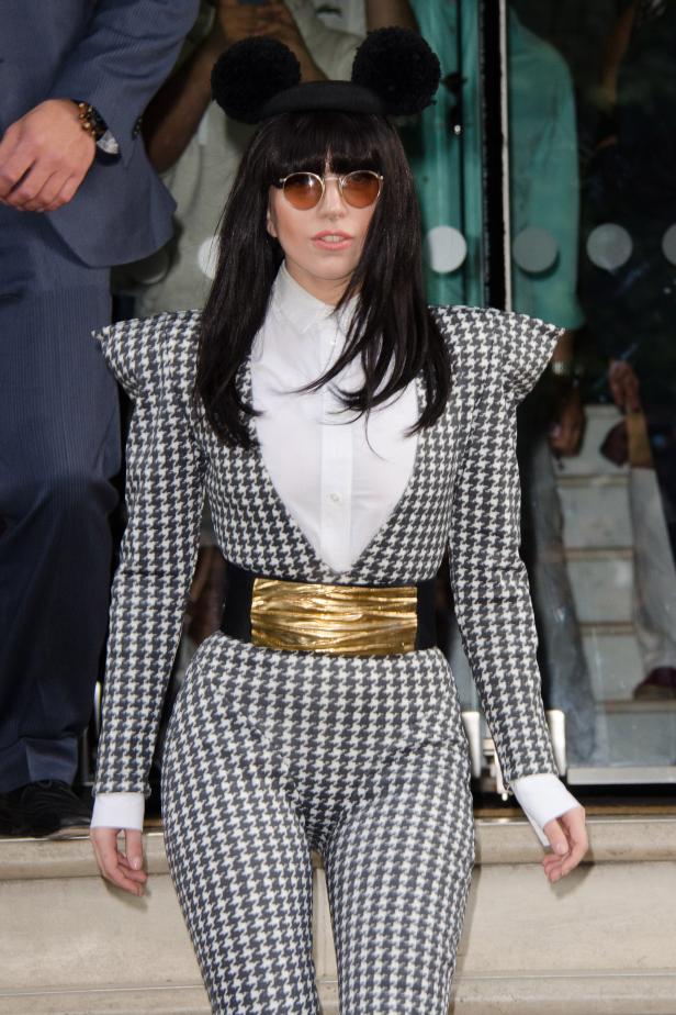 Lady Gaga trägt einen Hosenanzug mit Hahnentrittmuster und eine Haube mit Ohren.