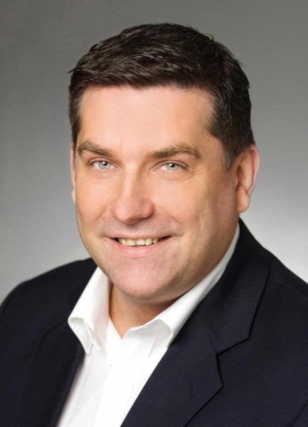 Manfred Litschka, von Österreich aus agierender TCC-Region-Manager, vermarktet Warner Bros-Charaktere für Promotions und Kundenbindungsprogramme. (c: tcc österreich) Ein Mann mit dunklen Haaren und einem dunklen Anzug lächelt in die Kamera.