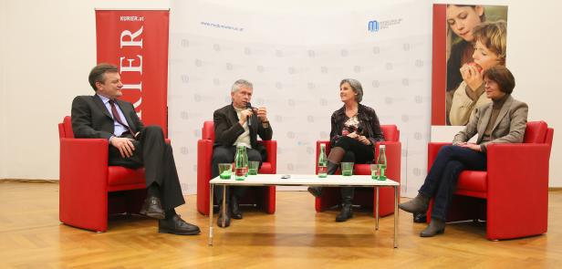 Vier Personen sitzen in roten Sesseln bei einer Podiumsdiskussion.