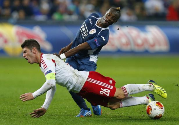 Zwei Fußballspieler kämpfen um den Ball auf dem Spielfeld.