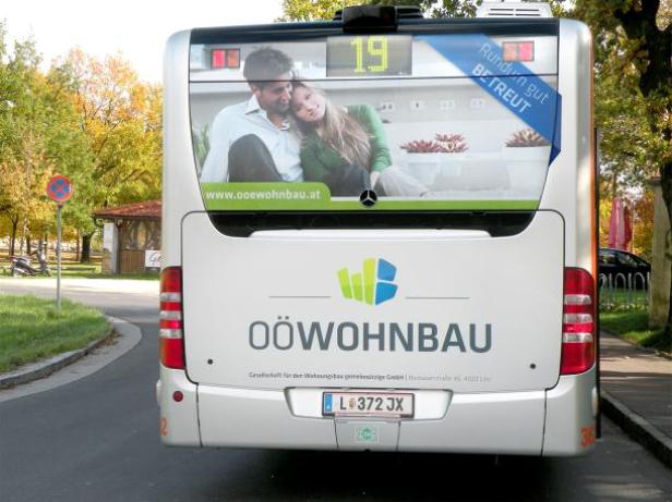 Ein Bus der OÖ Wohnbau mit einer Werbung für Wohnungen.
