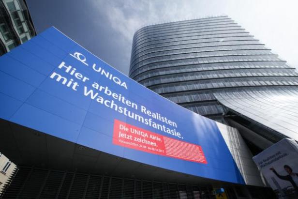 Ein großes UNIQA-Werbeplakat an einem modernen Bürogebäude.