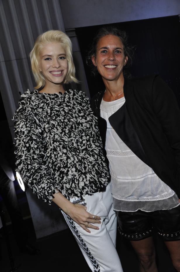 Zwei Frauen posieren lächelnd für ein Foto.