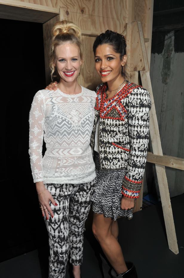 January Jones und Freida Pinto posieren zusammen vor einer Holzwand.
