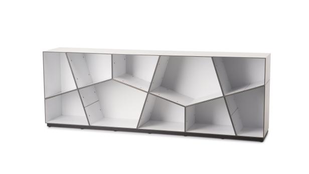 Ein weißes, modernes Regal mit geometrischen Fächern steht vor einem weißen Hintergrund.