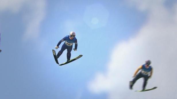 Zwei Skispringer sind vor blauem Himmel in der Luft.