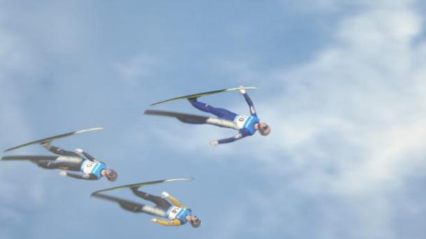 Drei Skispringer sind in der Luft vor einem blauen Himmel zu sehen.