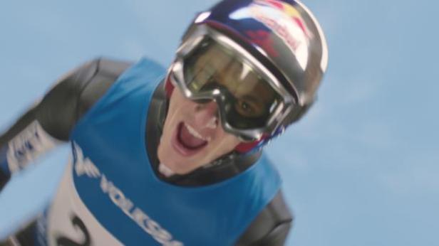 Ein Skirennfahrer mit Helm und Brille schreit während eines Rennens.