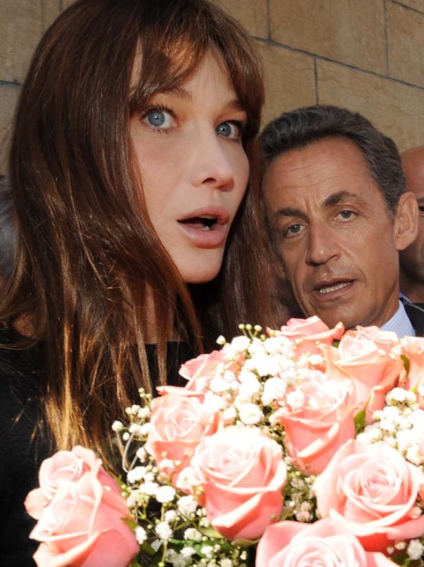 Carla Bruni und Nicolas Sarkozy mit einem Blumenstrauß.