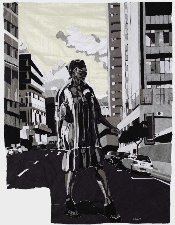 Eine Frau in einem gestreiften Kleid geht eine Straße in einer Stadt entlang.