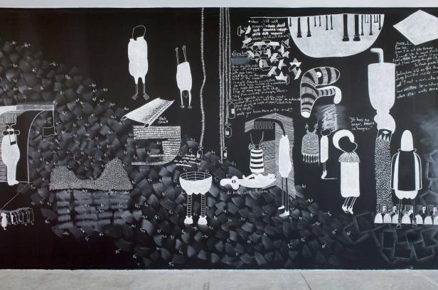 Eine Kreidezeichnung auf einer Tafel mit verschiedenen Figuren und Textfragmenten.