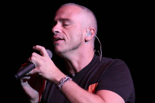 Ein Mann mit Mikrofon singt auf einer Bühne.