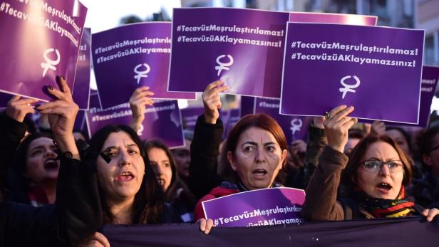 Frauen demonstrieren mit Schildern, auf denen „#TecavüzMeşrulaştırılamaz!“ steht.