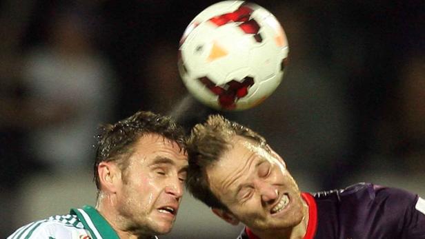 Zwei Fußballspieler köpfen gleichzeitig einen Ball.