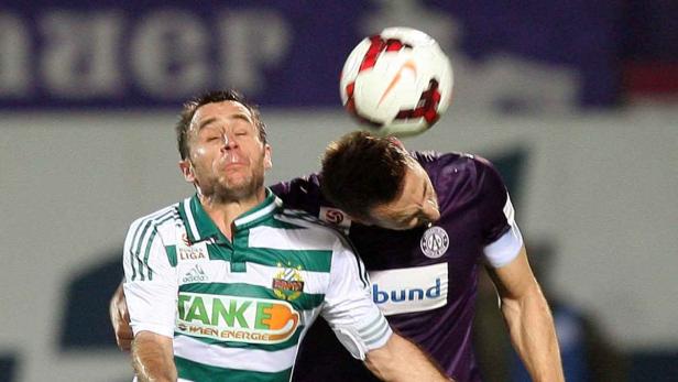 Zwei Fußballspieler kämpfen um einen Ball mit ihren Köpfen.