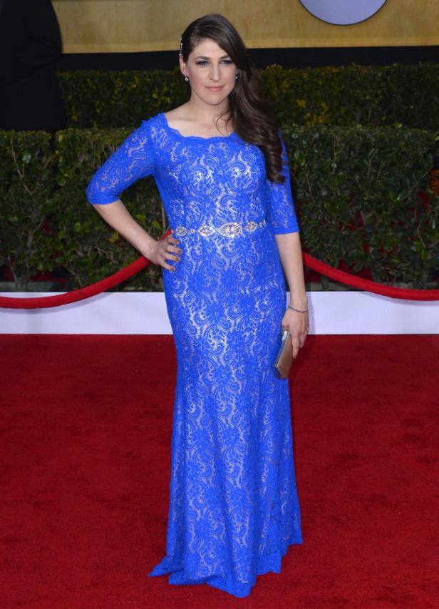 Mayim Bialik in einem blauen Spitzenkleid auf dem roten Teppich.