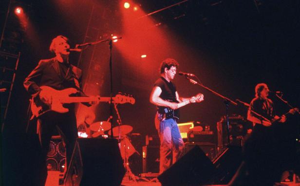 Eine Band tritt in rotem Bühnenlicht auf.