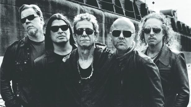 Die Band Metallica und Lou Reed posieren für ein Schwarzweißfoto vor einem Schiffsrumpf.