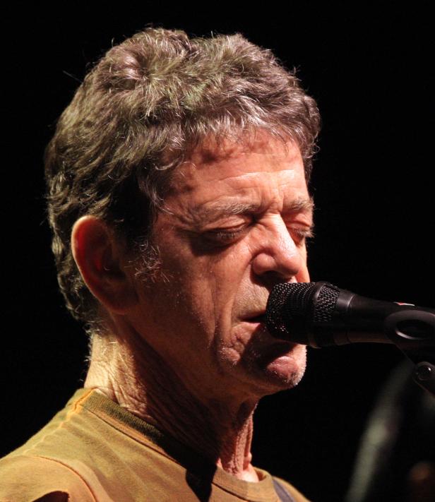 Lou Reed singt während eines Konzerts in ein Mikrofon.