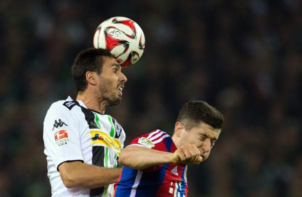 Zwei Fußballspieler kämpfen um den Ball bei einem Bundesligaspiel.