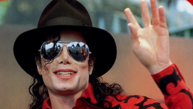 Michael Jackson mit Hut und Sonnenbrille winkt in die Menge.