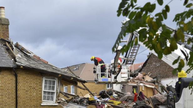 Ein Feuerwehrmann untersucht die Schäden an einem Haus nach einer Explosion.