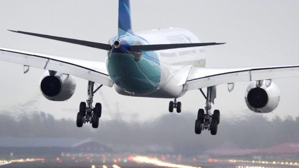 Ein Flugzeug landet auf einer Landebahn.
