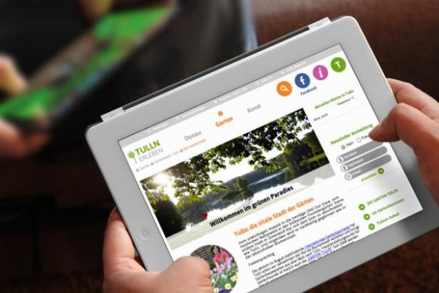 Eine Person nutzt ein Tablet, um die Webseite „Tulln erleben“ anzusehen.
