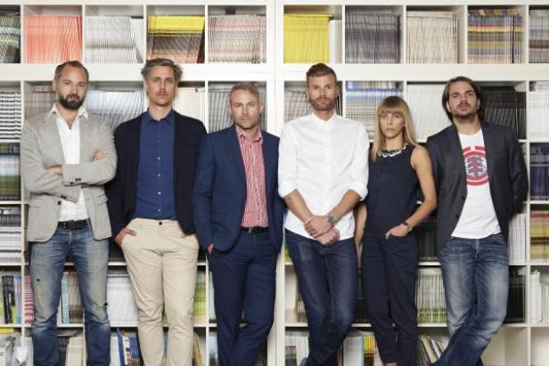 Sechs Personen posieren vor einem Bücherregal.