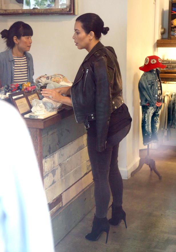 Kim Kardashian in einer schwarzen Lederjacke beim Einkaufen in einem Geschäft.