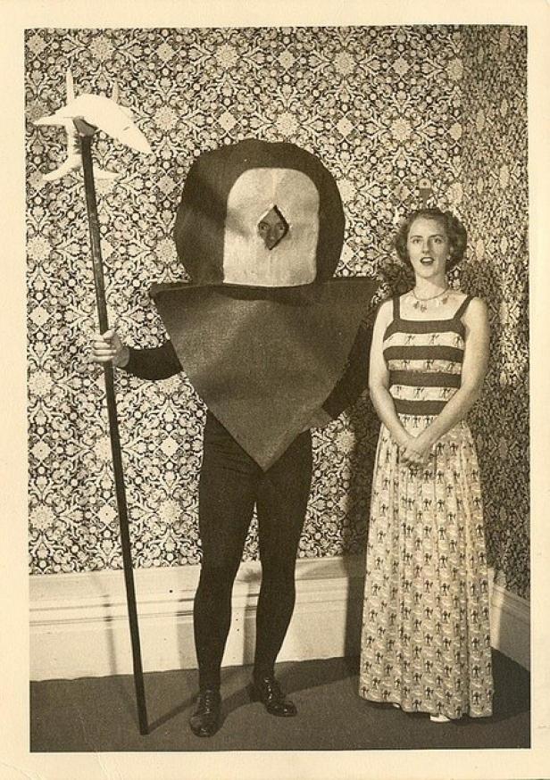 Eine Frau steht neben einer Person in einem ungewöhnlichen Kostüm mit Hellebarde.