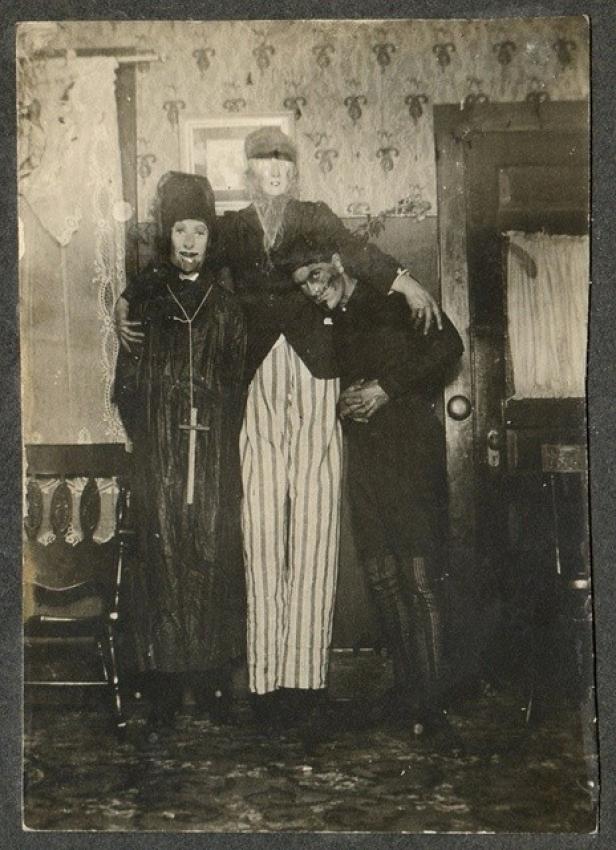 Drei Personen, verkleidet als Priester, Geist und Sträfling, posieren für ein Foto.