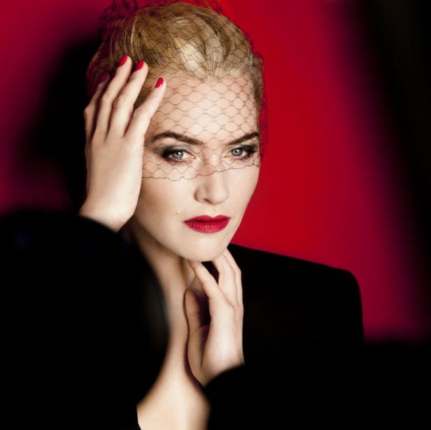 Eine Frau mit rotem Lippenstift und einem Schleier vor einem roten Hintergrund.