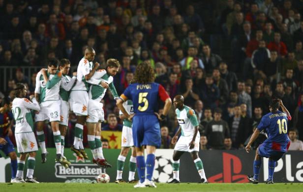Ronaldinho von Barcelona bereitet sich auf einen Freistoß vor, während die Bremer eine Mauer bilden.