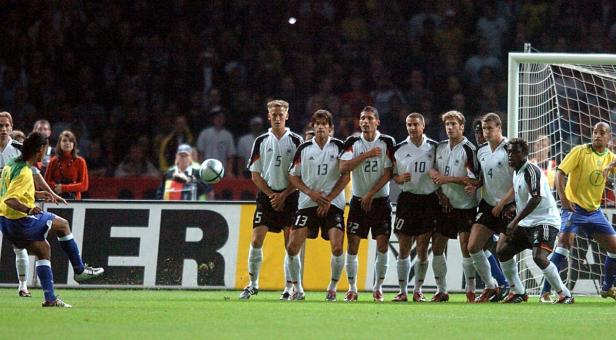 Ronaldinho schießt einen Freistoß gegen die deutsche Mauer.