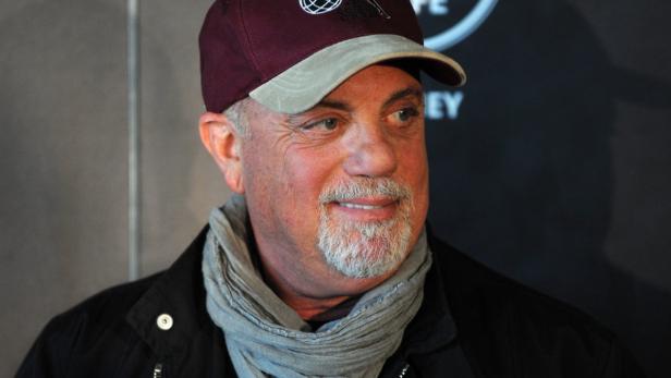 Billy Joel trägt eine Schirmmütze und einen Schal.