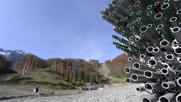 Ein Skihang mit Rohren im Vordergrund und Bergen im Hintergrund.