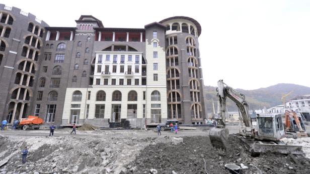 Ein Bagger steht vor einem großen Gebäude im Bau.