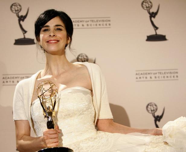 Sarah Silverman hält eine Emmy-Trophäe in einem weißen Kleid.