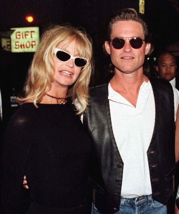 Goldie Hawn und Kurt Russell posieren zusammen vor einem Souvenirladen.