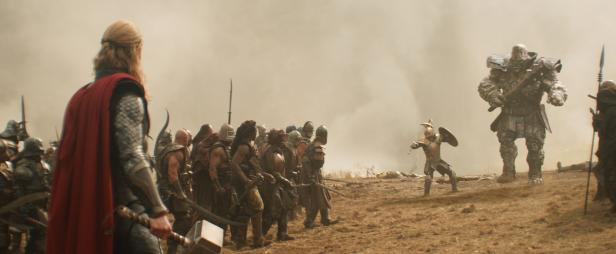 Thor steht mit seinem Hammer Mjölnir einer Armee und Korg gegenüber.