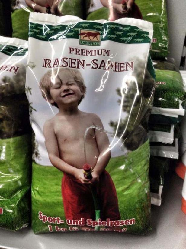 Eine Packung Rasensamen mit dem Bild eines Jungen, der mit einem Gartenschlauch spielt.