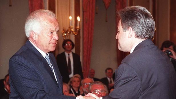 Zwei Männer in Anzügen schütteln sich die Hände.