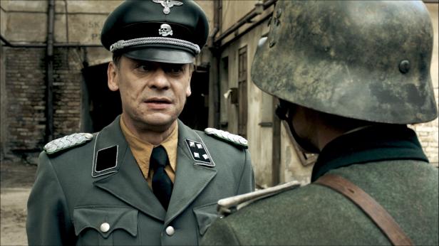 Ein Offizier der Wehrmacht spricht mit einem Soldaten.