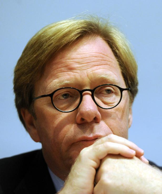 PODIUMSDIKUSSION "KLEINER BESSER ODER ANDERS": CER Ein Mann mit blonden Haaren und Brille hat die Hände vor dem Gesicht verschränkt.