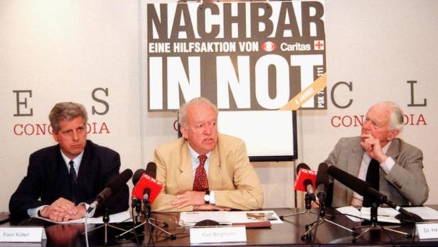Franz Küberl, Kurt Bergmann und Dr. He sitzen vor einem „Nachbar in Not“-Banner.