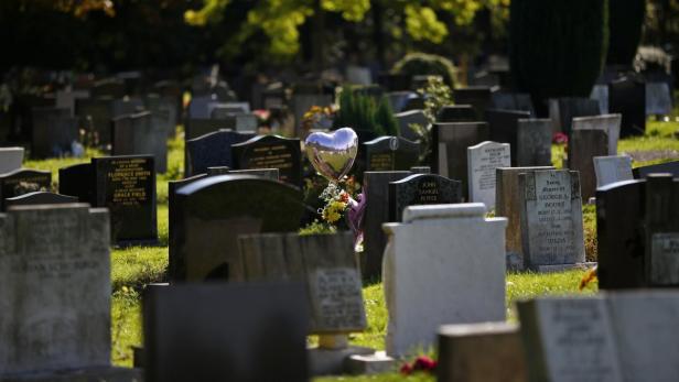 Ein Friedhof mit Grabsteinen und einem herzförmigen Ballon.