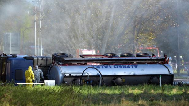 Ein umgekippter Tanklastwagen von „Alfred Talke“ wird von Einsatzkräften mit Wasser besprüht.