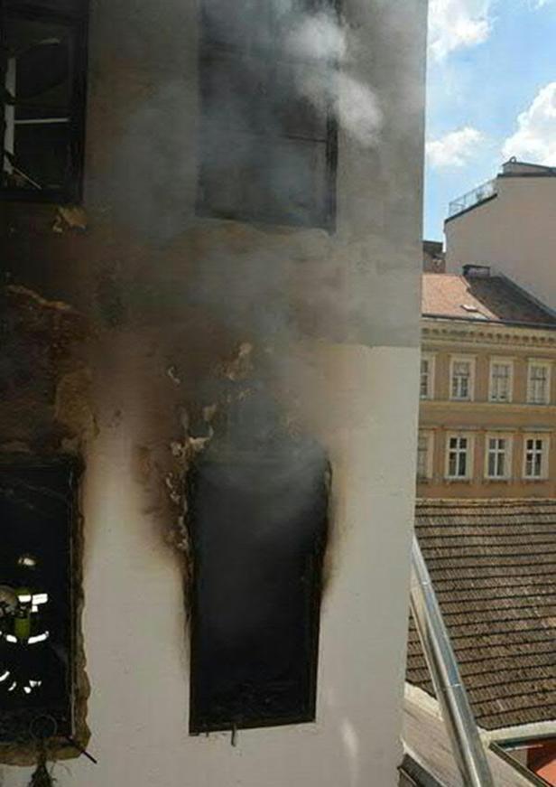Rauch quillt aus den verkohlten Fenstern eines Gebäudes.