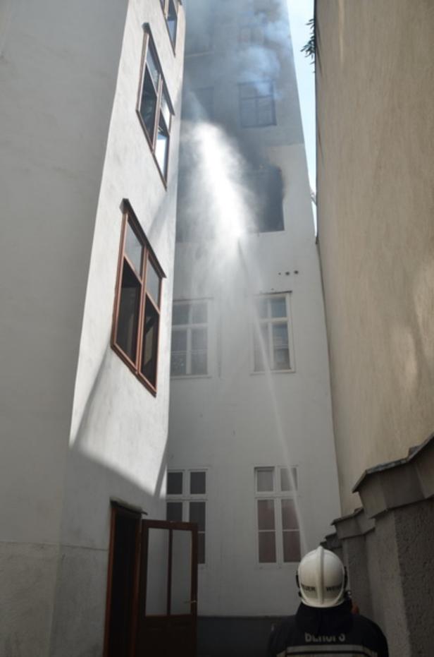 Ein Feuerwehrmann löscht einen Brand in einem Gebäude.